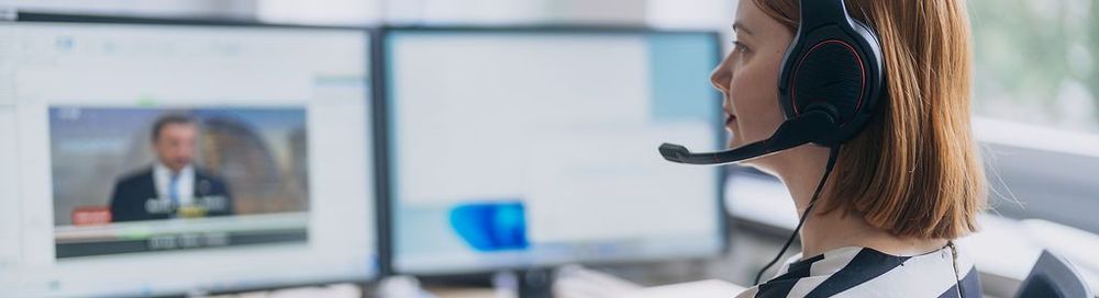 Eine Frau mit Headset sitzt an einer Tastatur und schaut dabei auf zwei Monitore. | Bildquelle: WDR mediagroup GmbH Eine Frau mit Headset sitzt an einer Tastatur und schaut dabei auf zwei Monitore.