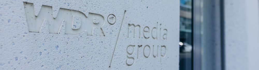 Das Logo der WDR mediagroup ist in die Hauswand eingefräst. | Bildquelle: WDR mediagroup GmbH Das Logo der WDR mediagroup ist in die Hauswand eingefräst.