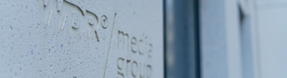 Das Logo der WDR mediagroup ist in die Hauswand eingefräst. | Bildquelle: WDR mediagroup GmbH Das Logo der WDR mediagroup ist in die Hauswand eingefräst.